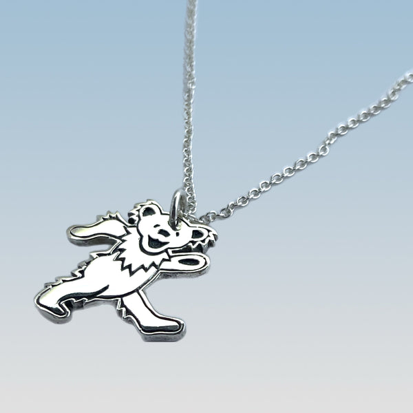 Silver necklace with a bear pendant on a light blue background